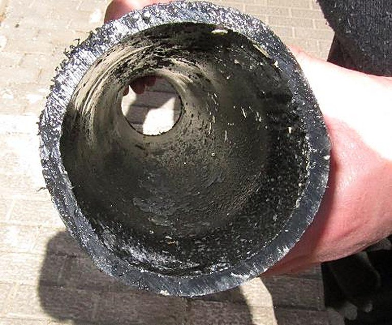 Interior de tubería durante la fase de desincrustación: el sarro duro se convierte en residuo blando que el agua arrastra
